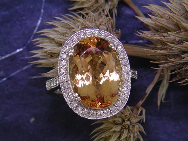 10.80 carat precious topaz accented by .51 carat of round diamond side stones.