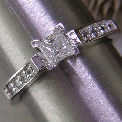 14K white gold cathedral shouldered ring with princess cut center stone.