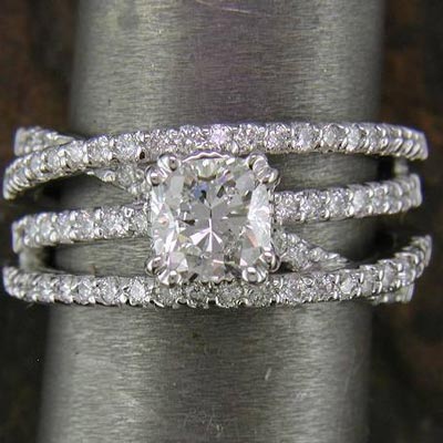 14K white gold with cushion cut diamond center stone. It's available for other center stone shapes. Depending on center stone, ring weighs 7-10 grams with 68-70 .01 ct. RBC's. 2 carat version takes 62 x .015's.